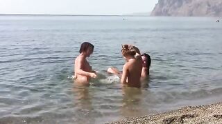 Three girls with puffed tits sunbathe on the naked beach