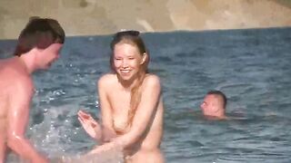 A mature woman gets her body oiled on the nudist beach