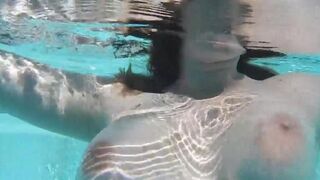 A woman plays with a dildo in the pool, getting wet