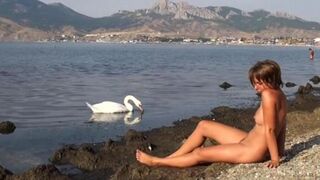A hot naked girl is having fun on the riverbank, it's very risky