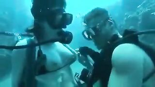 Underwater sex of two aqualangists at sea bottom