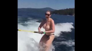 Topless girl water skiing on the tube