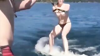 Topless girl water skiing on the tube