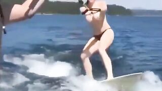 Topless girl water skiing on the tube