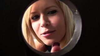 The blonde is greedily sucking a cock through the toilet hole