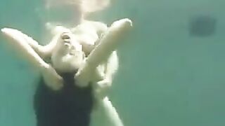 The busty brunette beauty is having fun with her partner in the ocean