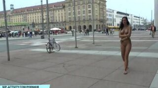 A hot chick is walking naked on the streets of the city