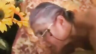 A mature gray-haired woman in black stockings gets fucked
