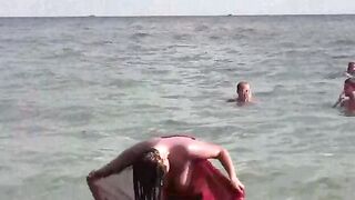 A moment of naked bathing in the sea, under the vast sky