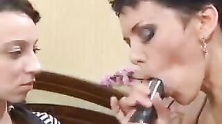 A mother teaches her daughter how to perform a blowjob with a strapon