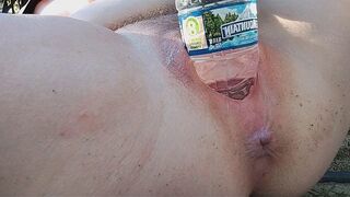 A girl reached the peak of pleasure while indulging in outdoor play with a water bottle